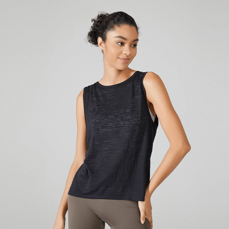 Woman wearing a sporty black tank top with cut on back, perfect for fitness like Pilates and running. Lightweight comfort with cotton and spandex.